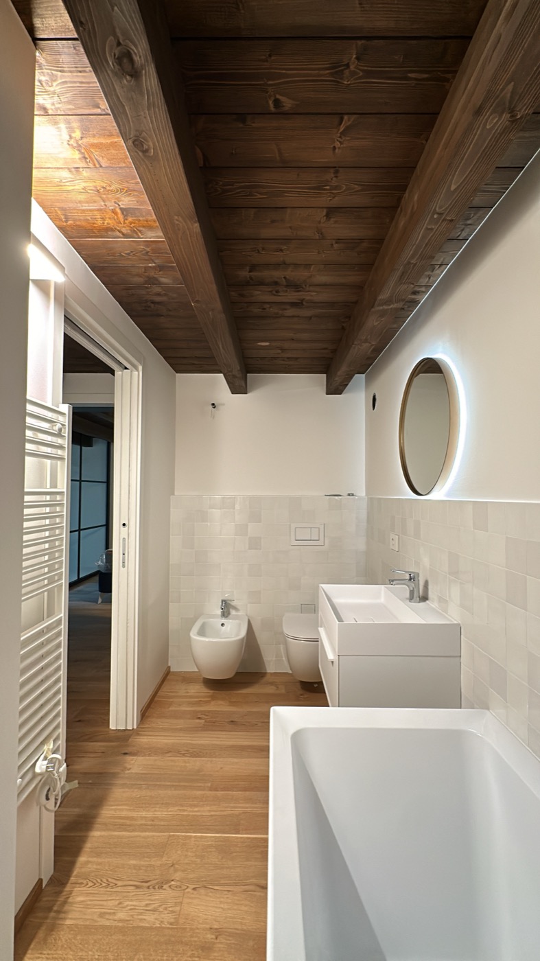 Bagno ristrutturato con soffitto in legno